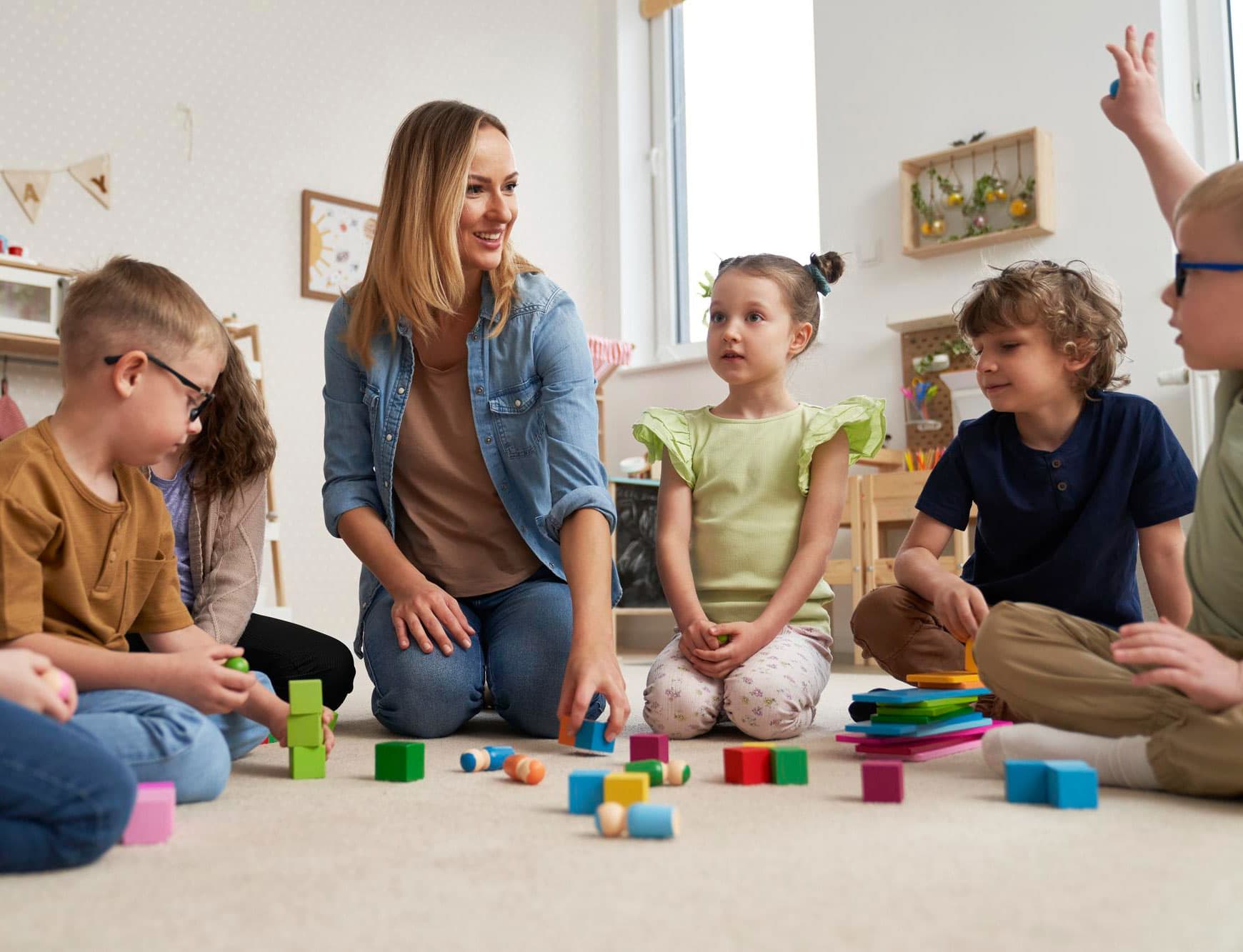 A teacher playing with children at Creative Playrooms Solon